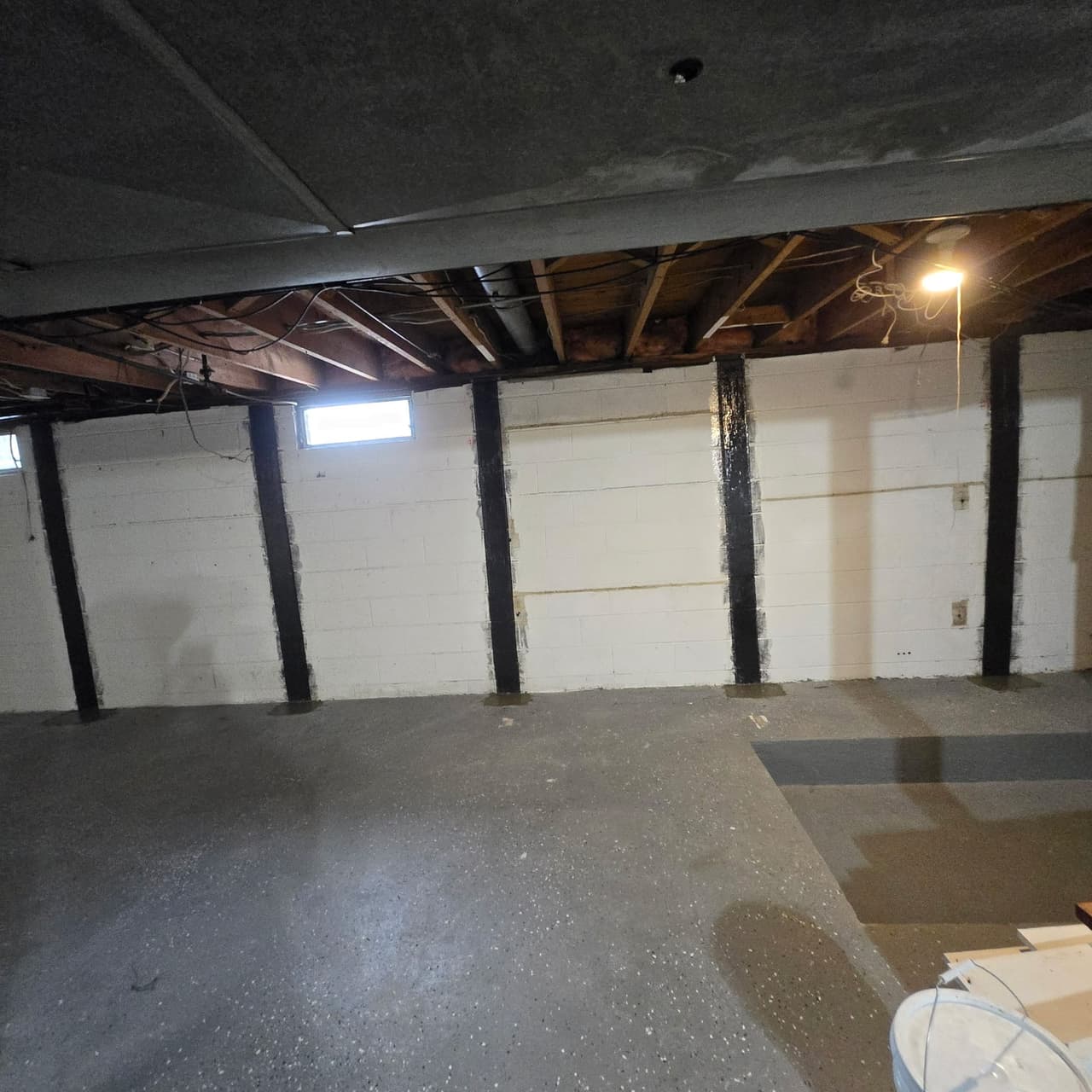 Basement wall reinforcement straps installed by Sunshine Waterproofing