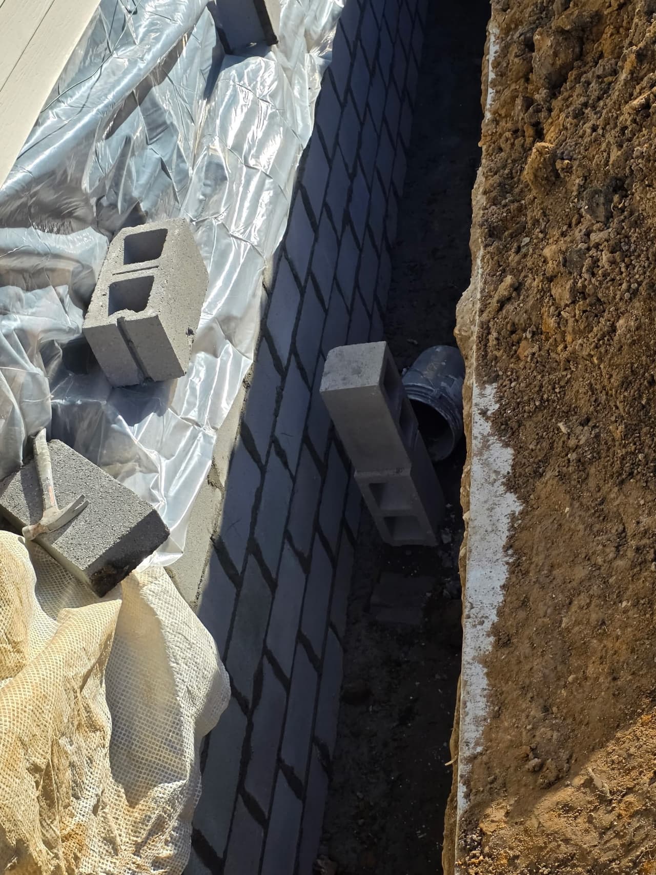 Exterior waterproofing membrane and drain work along a foundation wall