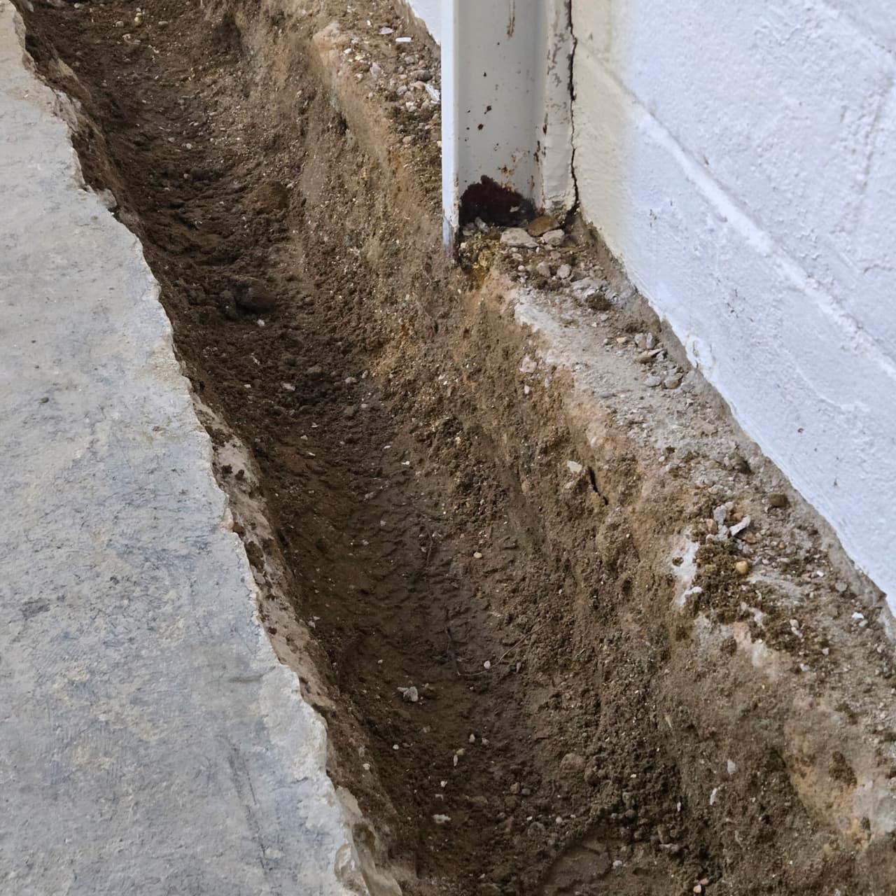 Interior basement drainage trench opened along the wall